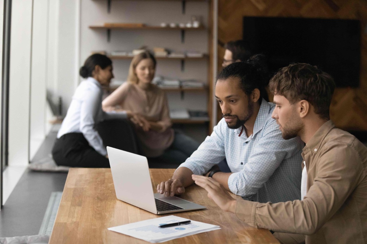 Two people working on a project together using a laptop Two people working on a project together using a laptop